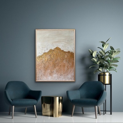 Sala com duas cadeiras azuis, mesa dourada, planta em vaso dourado e quadro abstrato na parede azul.