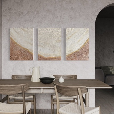 Mesa de jantar com cadeiras de madeira clara, decoração abstrata tripla na parede e arco para outra divisão.