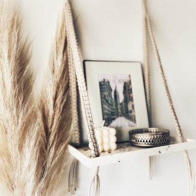 Prateleira branca pendurada com vela, porta-velas metálico e moldura com imagem da cidade de Nova Iorque