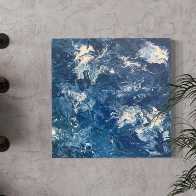 Pintura abstrata azul e branca numa parede cinzenta com estante e plantas ao lado
