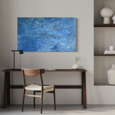 Mesa de madeira escura com cadeira de madeira clara e assento trançado, quadro azul abstrato na parede e estantes embutidas com objetos brancos.