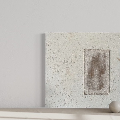 Mesa com vasos em cerâmica e quadro abstrato encostado na parede