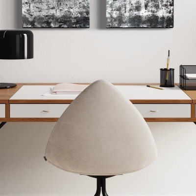 Dois quadros abstratos em preto e branco numa parede branca acima de uma secretária de madeira clara com tampo branco, com cadeira bege frontal e candeeiro preto ao lado.