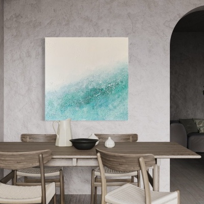 Mesa de jantar de madeira clara com cadeiras estofadas e quadro abstrato azul e branco na parede cinzenta