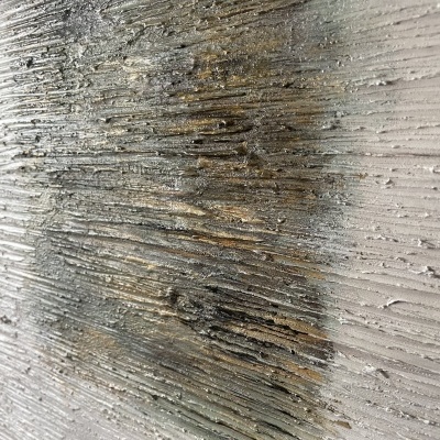 Superfície texturada com sulcos irregulares em tons de cinza e preto.