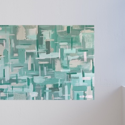 Quadro abstrato em tons de verde, azul e branco numa parede branca com planta e livros próximos