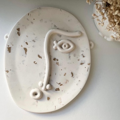 tabuleiro decorativo oval marmoreado com desenho de face em relevo