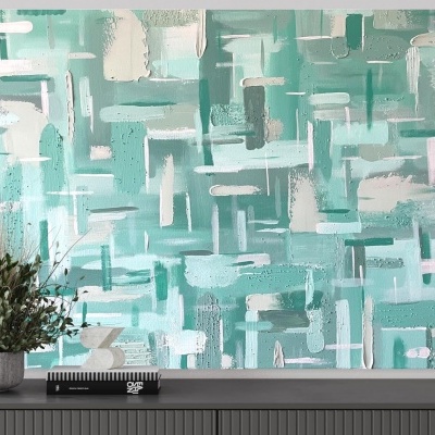 Tela decorativa abstrata verde água e branco sobre móvel cinzento com planta e livro