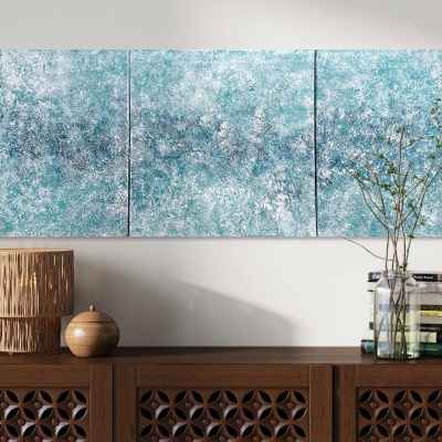Triplo painel abstrato azul e branco acima de móvel de madeira com vaso e candeeiro