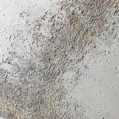 Superfície branca com textura granular cinzenta clara e manchas escuras