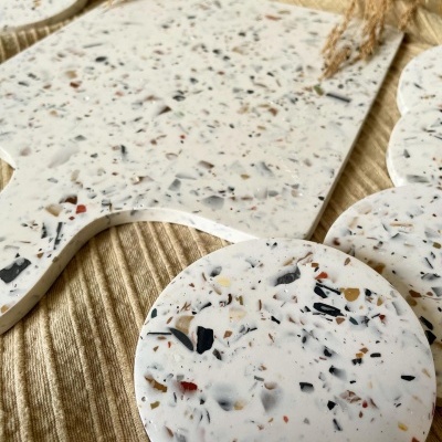 Tábuas e bases redondas tipo mármore com padrão colorido sobre tecido amarelo