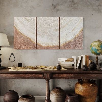 Mesa rústica com lâmpada, livros, globo e vasos, parede cinzenta com três painéis decorativos