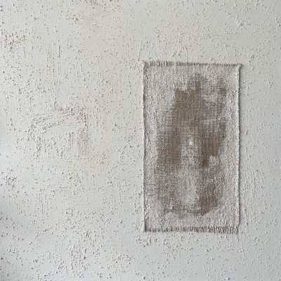 Tapete retangular cinzento e bege sobre superfície branca texturizada