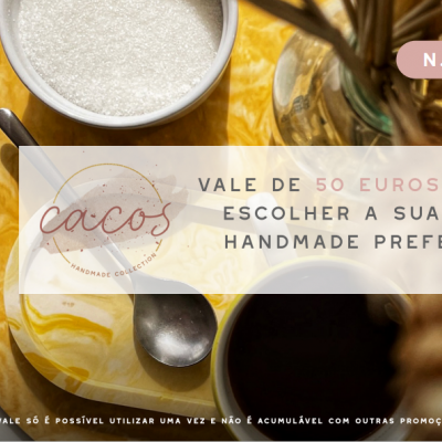 Duas xícaras sobre superfície amarela marmoreada com colher metálica e objeto decorativo dourado