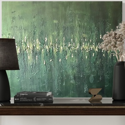 Mesa de madeira escura com abajur preto, livros, vaso preto com ramos secos e tela abstrata verde na parede