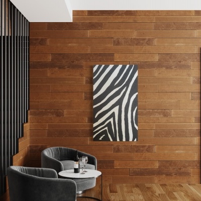 Sala interior com parede de madeira, quadro zebra, duas cadeiras cinzentas e mesa redonda branca.