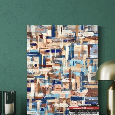 Quadro decorativo abstrato em tons azuis e castanhos sobre móvel com candeeiro dourado e vela