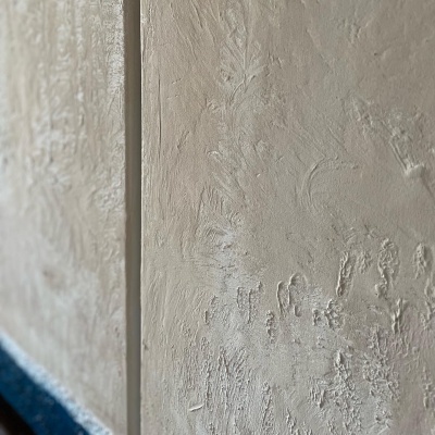 Parede texturizada clara com linha divisória vertical e base azul escuro