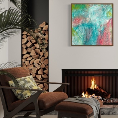 Cadeira e banco castanhos com manta e almofada, lareira acesa, lenha empilhada e quadro abstrato colorido