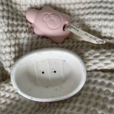 Estojo de saboneteira branca pontilhada e brinquedo rosado de ovelha com correia branca