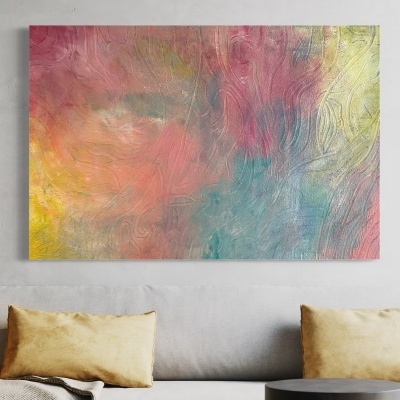 Tela de pintura abstrata colorida pendurada numa parede cinzenta acima de sofá e mesas.