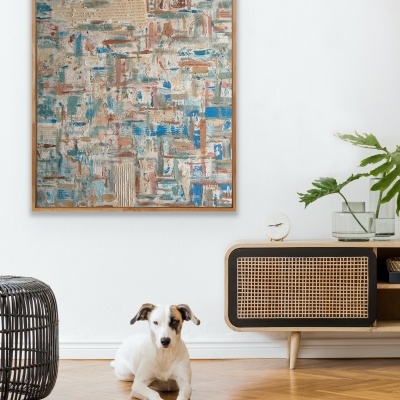 Quadro decorativo abstrato com moldura em madeira numa sala com móvel de madeira e cão no chão