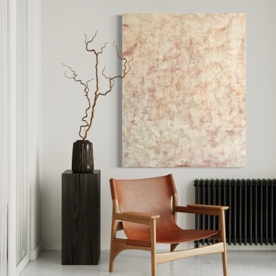 Cadeira de couro castanho, vaso preto com ramo seco, radiador preto e pintura abstrata numa sala clara.