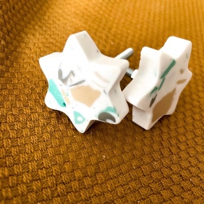 Puxadores de mobília estrela em cerâmica com padrão abstrato sobre tecido castanho