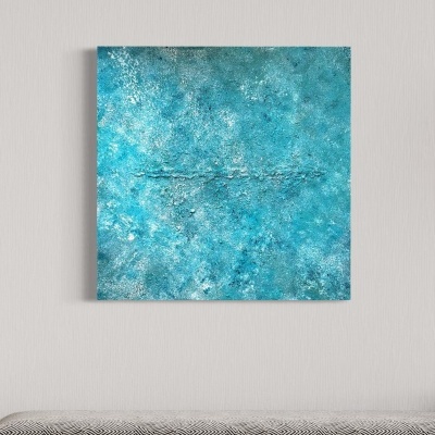 Quadro abstrato azul esverdeado pendurado sobre banco com almofada cinzenta e padrão geométrico