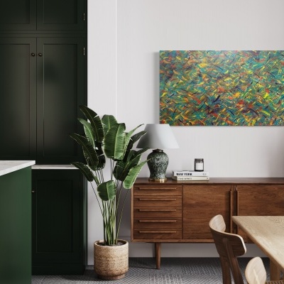 Cozinha moderna com armários verdes, ilha branca, sala de jantar com mesa e cadeiras de madeira, planta grande e arte colorida na parede