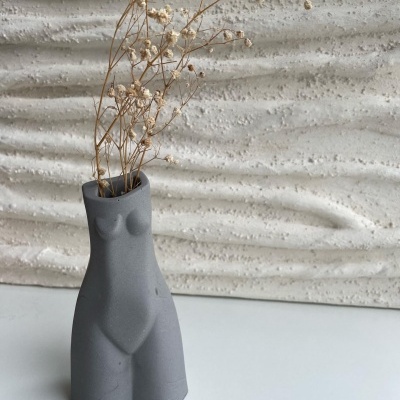 Vaso cinzento forma corpo feminino com flores secas