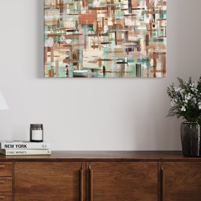 Quadro abstrato colorido pendurado na parede acima de aparador de madeira com livros, vela e vaso com flores