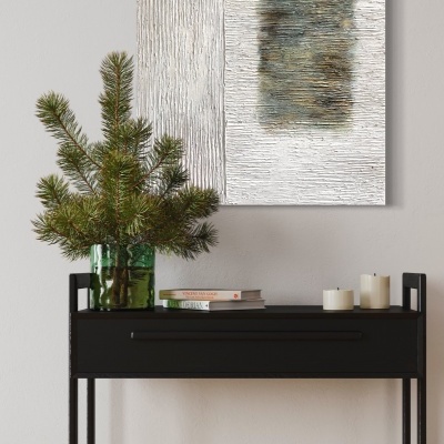 Mesa consola preta com vaso de pinheiro, livros e velas, quadro abstrato na parede branca