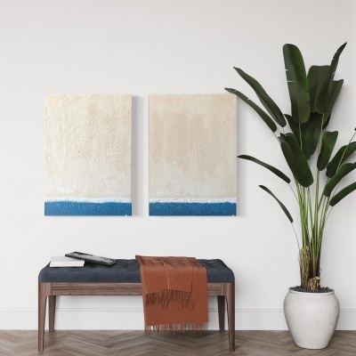 Banco com assento azul escuro, lenço castanho, duas telas abstratas na parede e planta em vaso branco