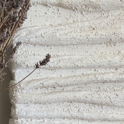 Painel decorativo branco texturizado com ramo seco ao lado