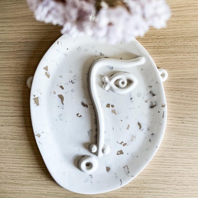 Prato decorativo oval branco com padrão castanho e desenho 3D de rosto estilizado