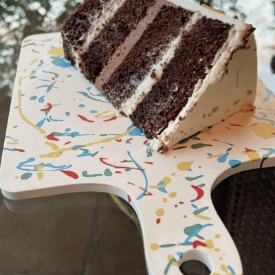 fatia de bolo de chocolate com creme sobre tábua branca colorida