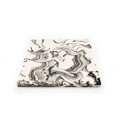 Azulejo quadrado com padrão marmoreado preto e branco sobre fundo branco