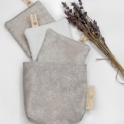 Conjunto de panos bege e branco com etiquetas e ramo seco de flores roxas