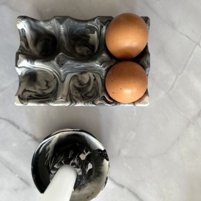 Tabuleiro marmoreado com ovos castanhos em superfície branca