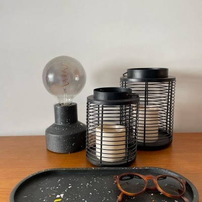 Lâmpada, lanternas, tabuleiro e óculos sobre mesa de madeira