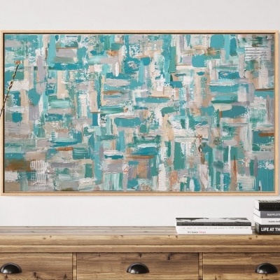 Quadro abstrato em tons azul e bege sobre cómoda de madeira com vaso e livros