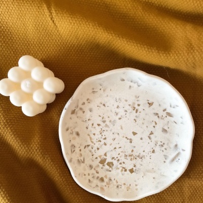 Prato branco marmoreado e vela branca em tecido amarelo mostarda