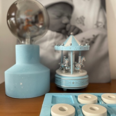 Lâmpada azul, carrossel decorativo azul e branco, jogo da velha azul e branco numa superfície de madeira