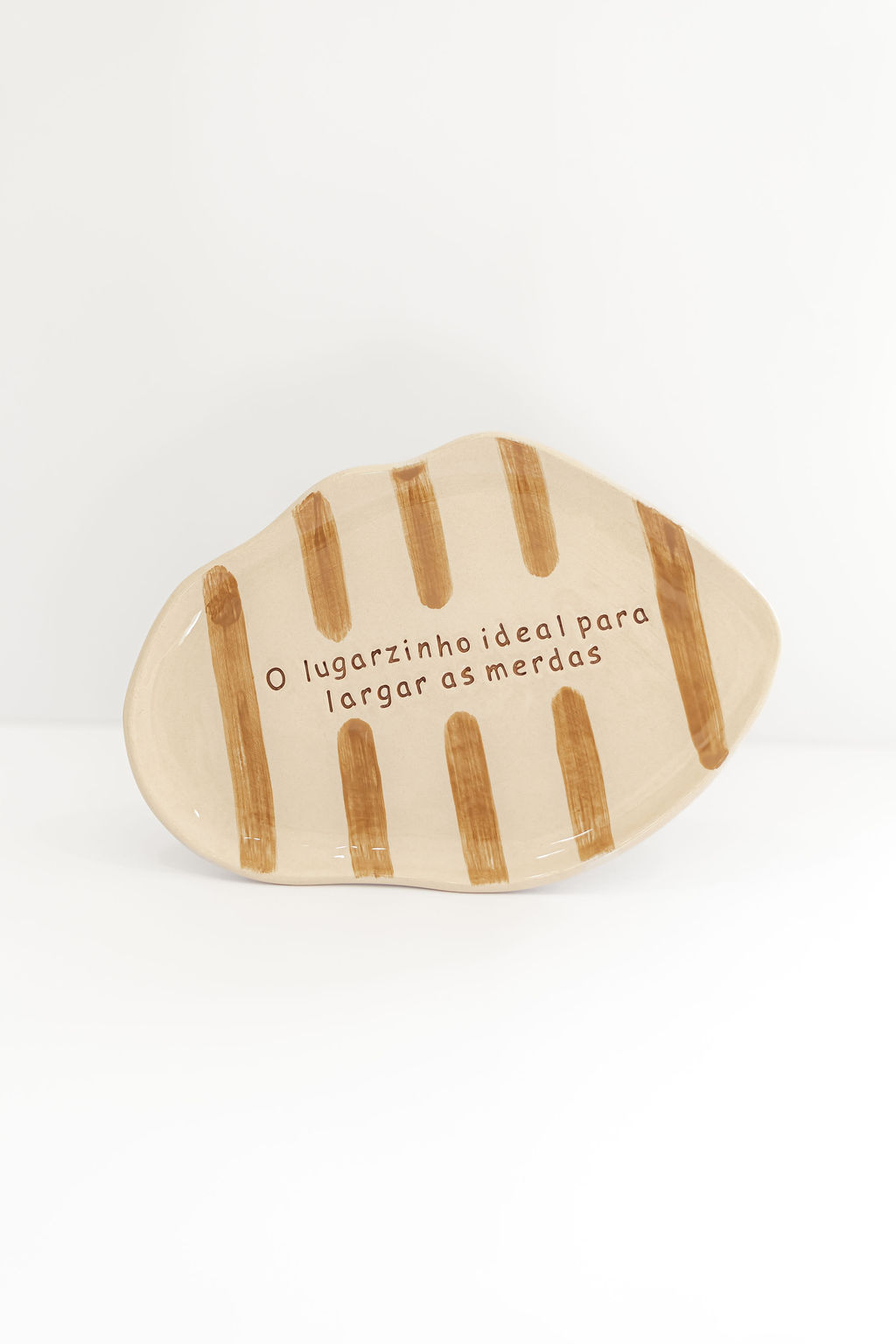 Prato cerâmico irregular com riscas castanhas e texto impresso