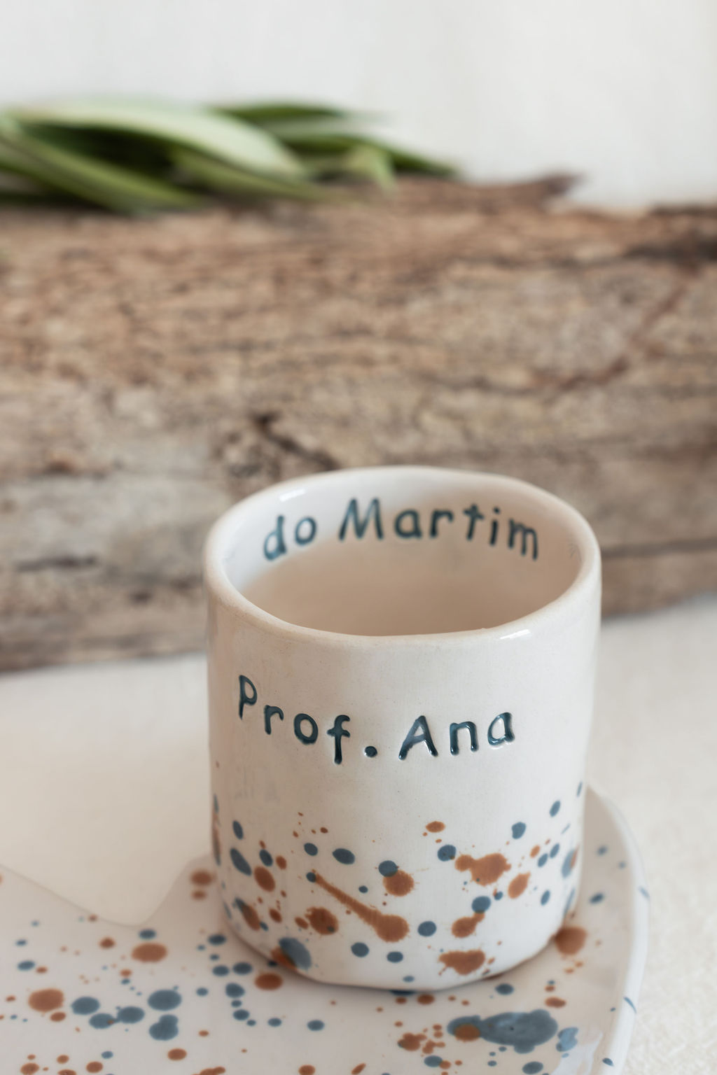 caneca cerâmica branca com salpicos castanhos e azuis e texto Prof. Ana do Martim