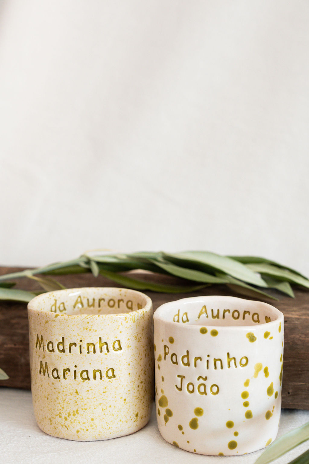 Dois copos cerâmicos manchados com textos personalizados em português