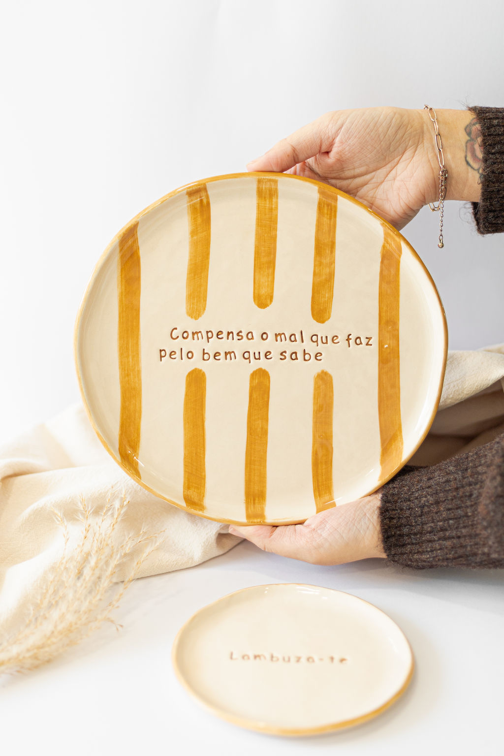 Prato decorativo oval com riscas castanhas e texto em português