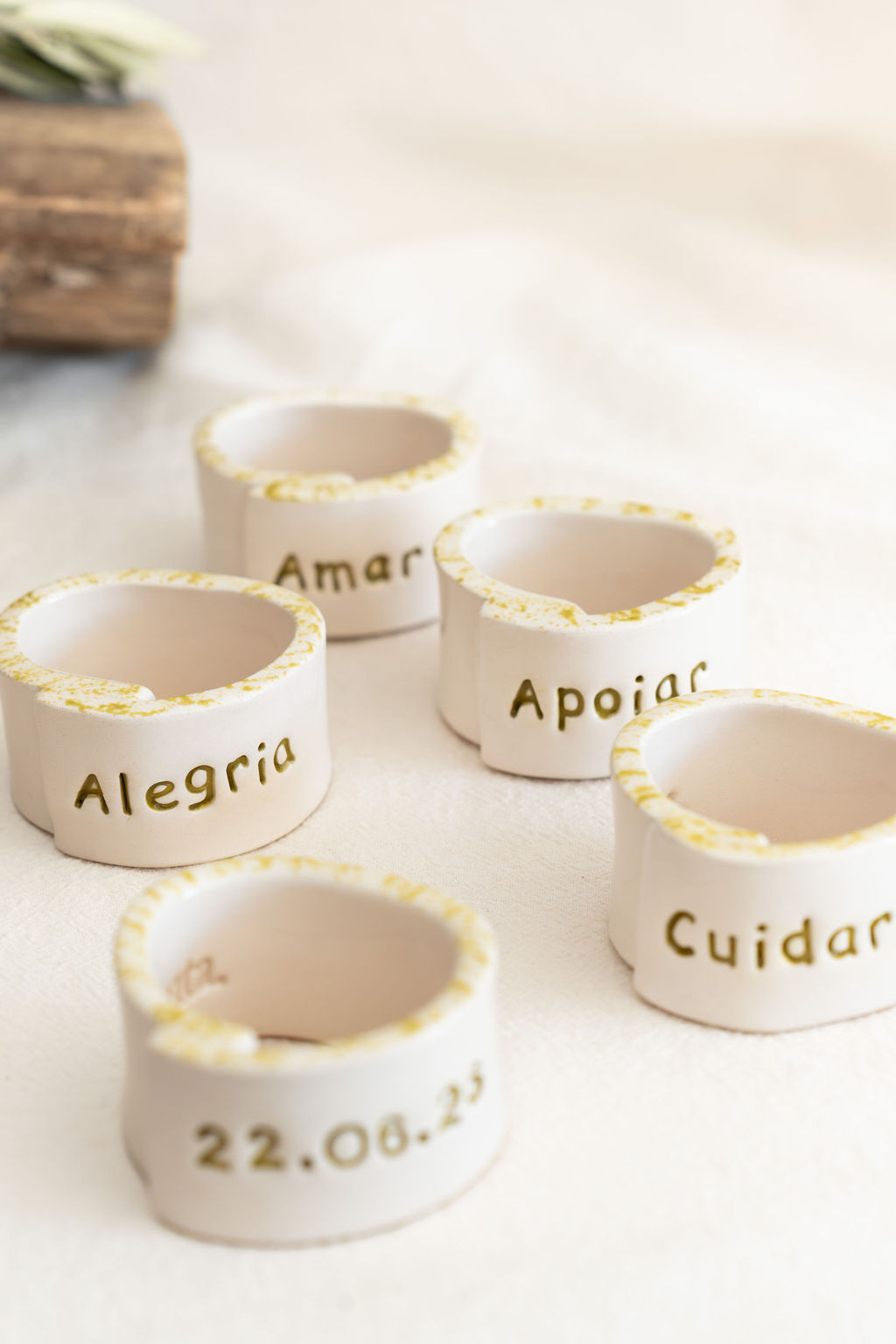 Cinco argolas de cerâmica branca com bordas amarelas e palavras gravadas