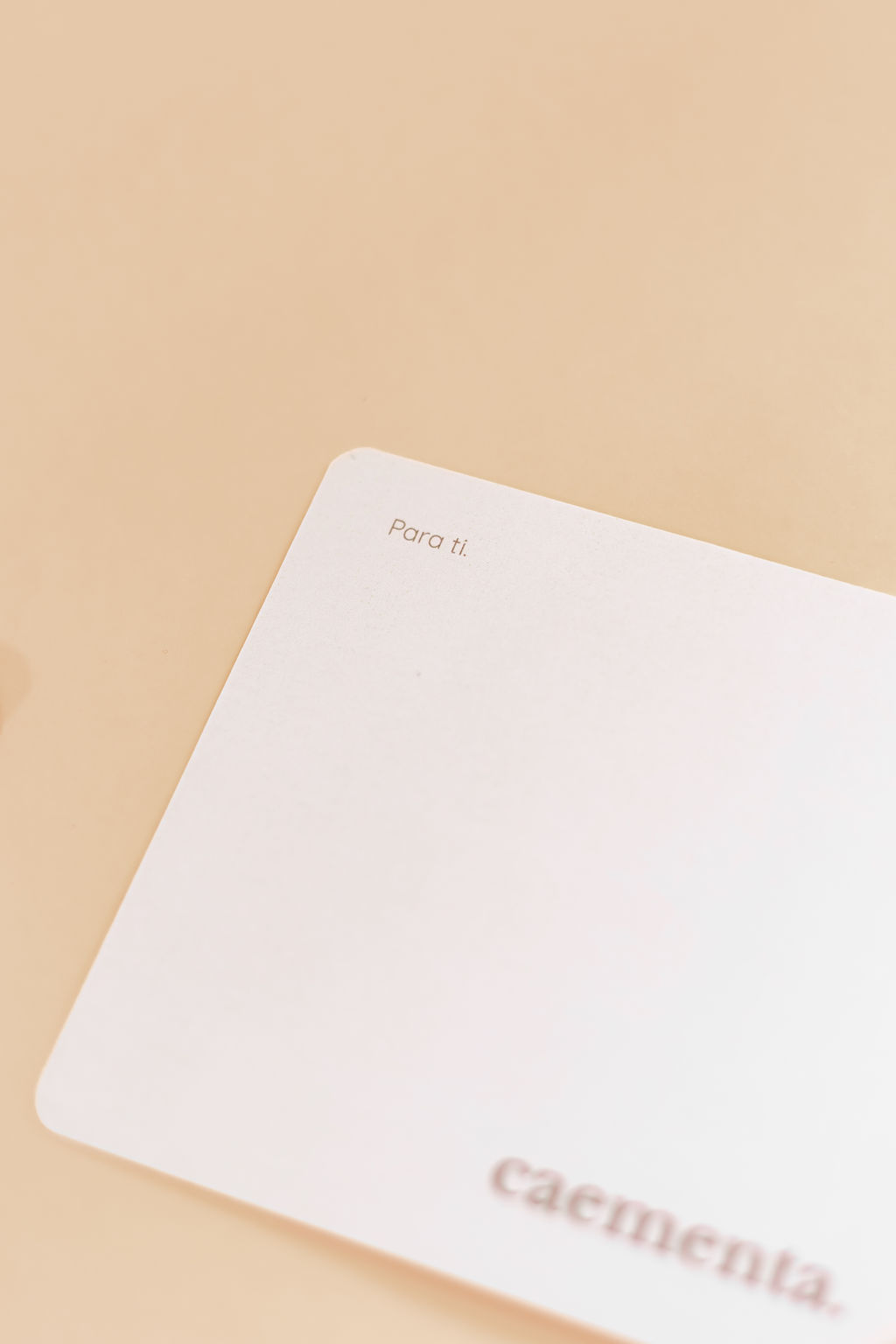 Cartão branco com texto Para ti. e caementa. sobre fundo bege